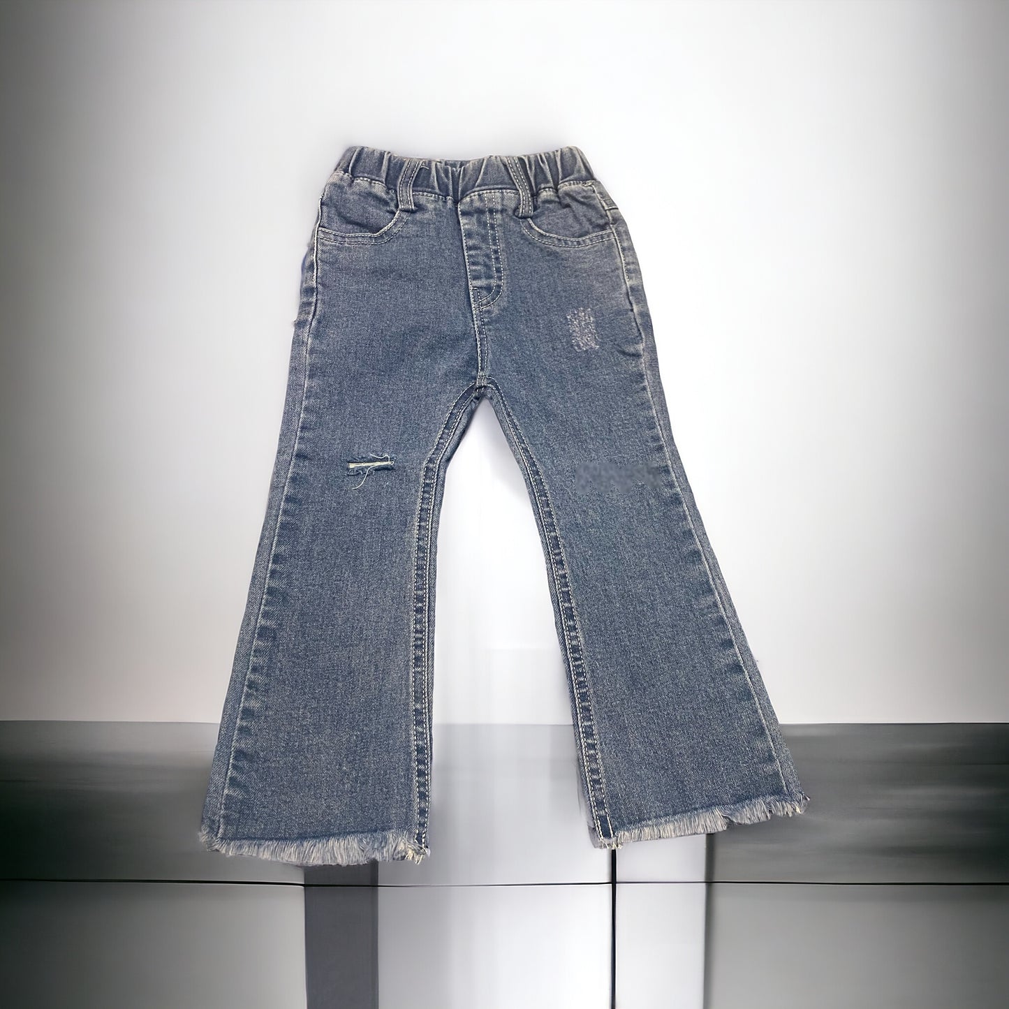 Flared distressed fringe bottom jeans
